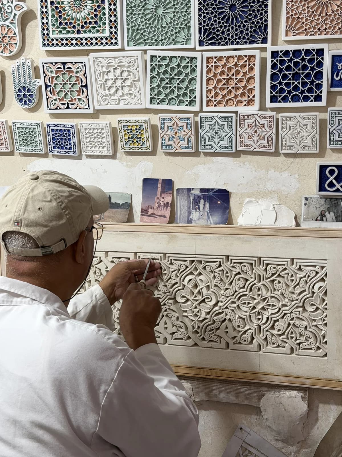An artisan carving a decorative plaster panel by hand in Marrakech
