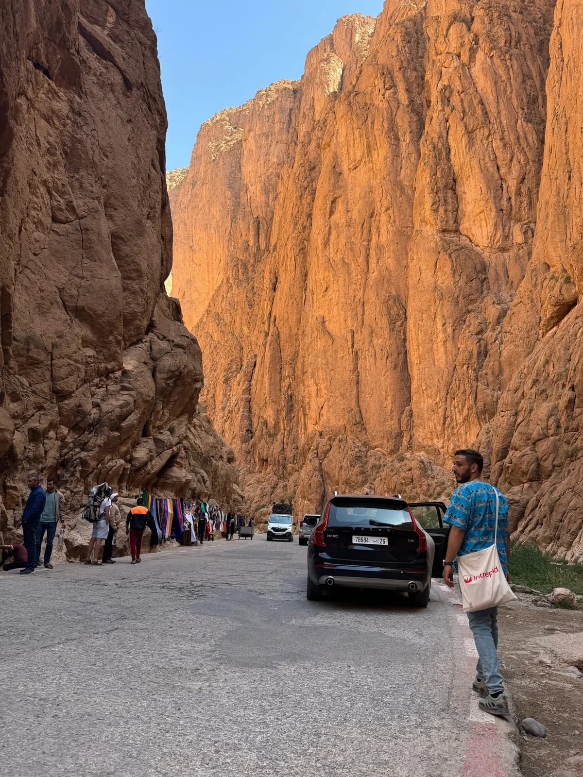 Tall orange rock walls beside the road through Todra Gorge